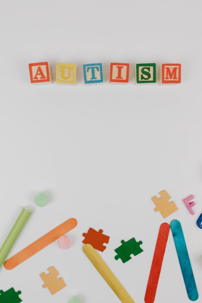 Colorful autism awareness display with blocks and puzzle pieces on a white background.